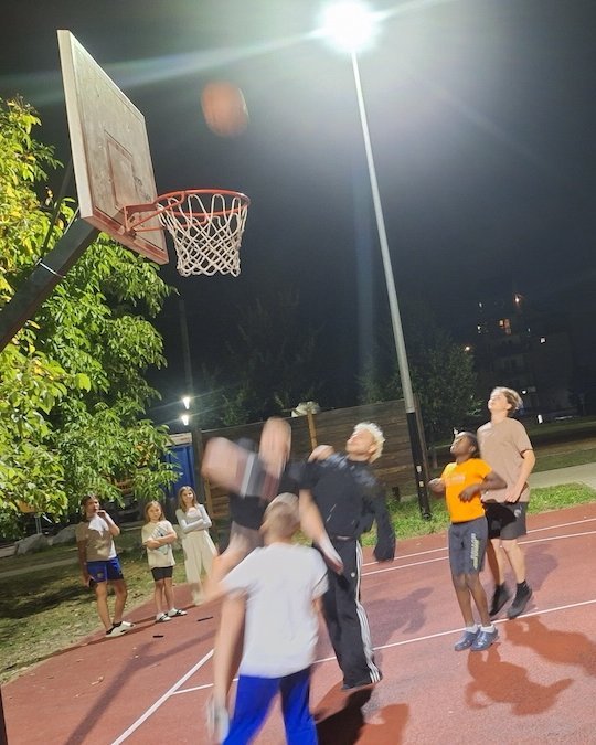 Jungs beim Basketballspiel auf dem nächtlichen Sportplatz